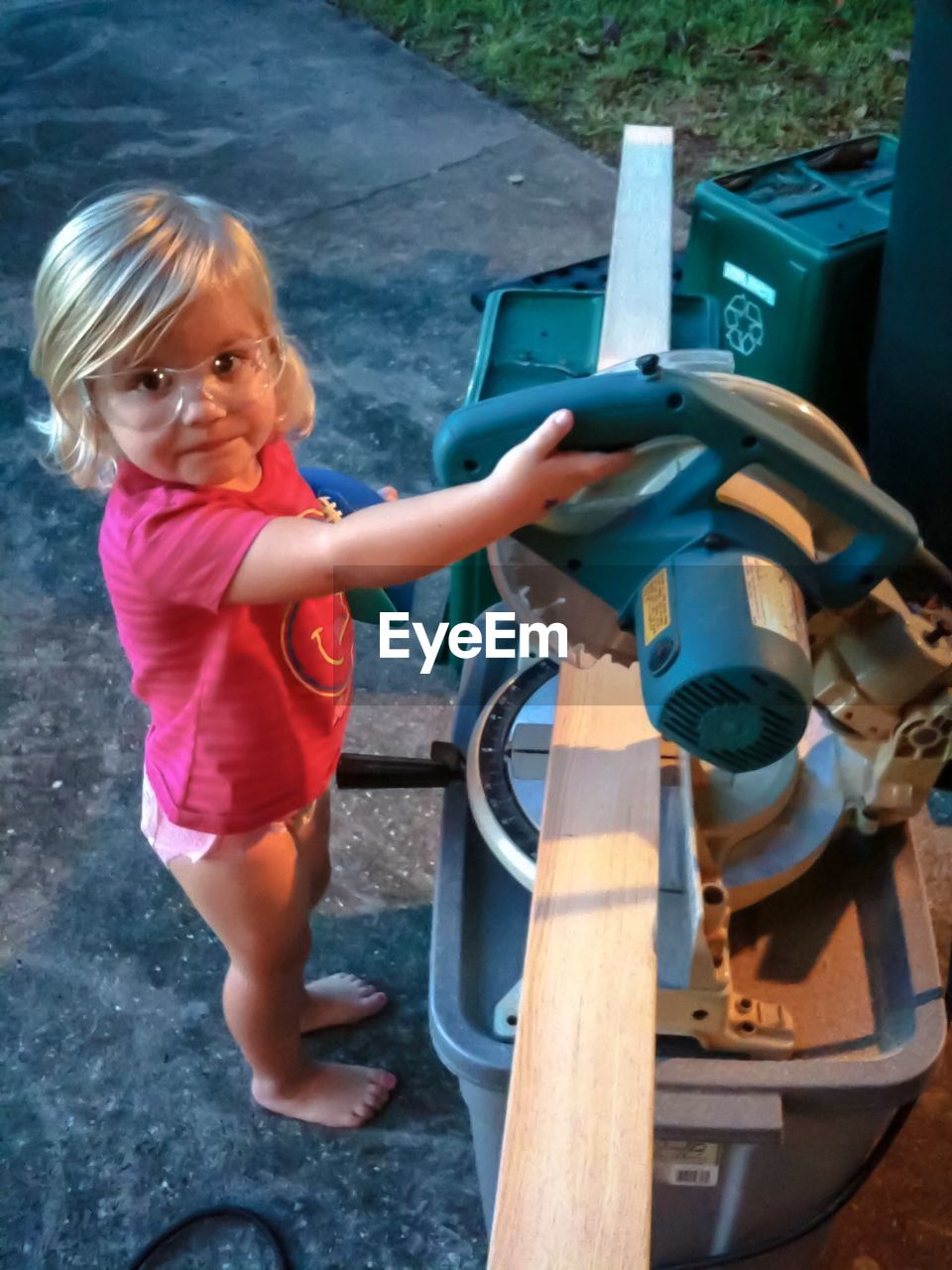 High angle portrait of girl holding machinery