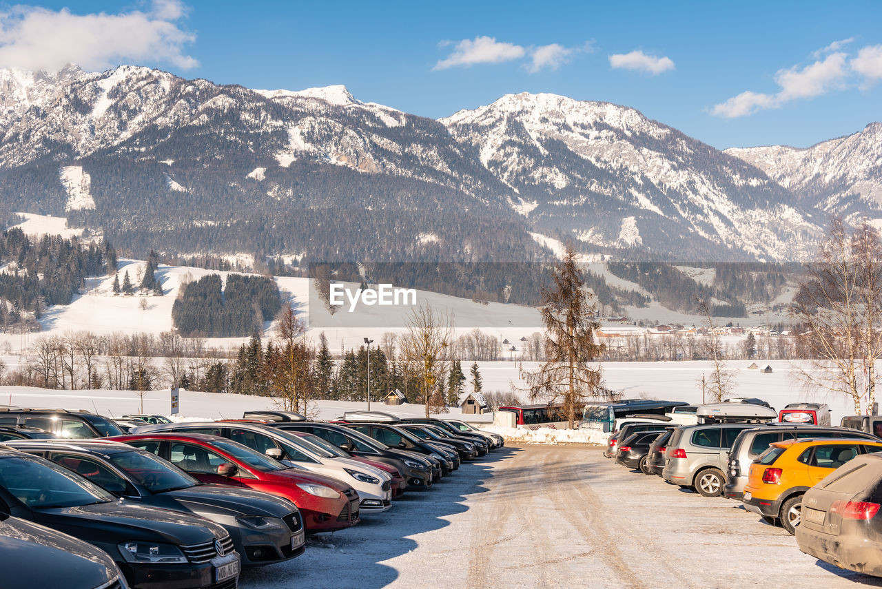 PANORAMIC VIEW OF CARS ON SNOWCAPPED MOUNTAIN