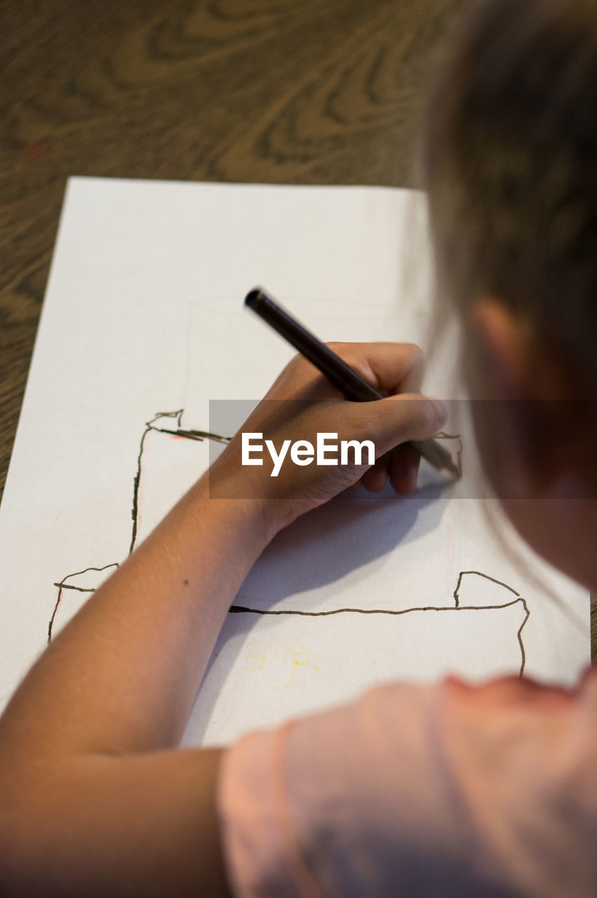 Close-up of girl drawing on paper at home