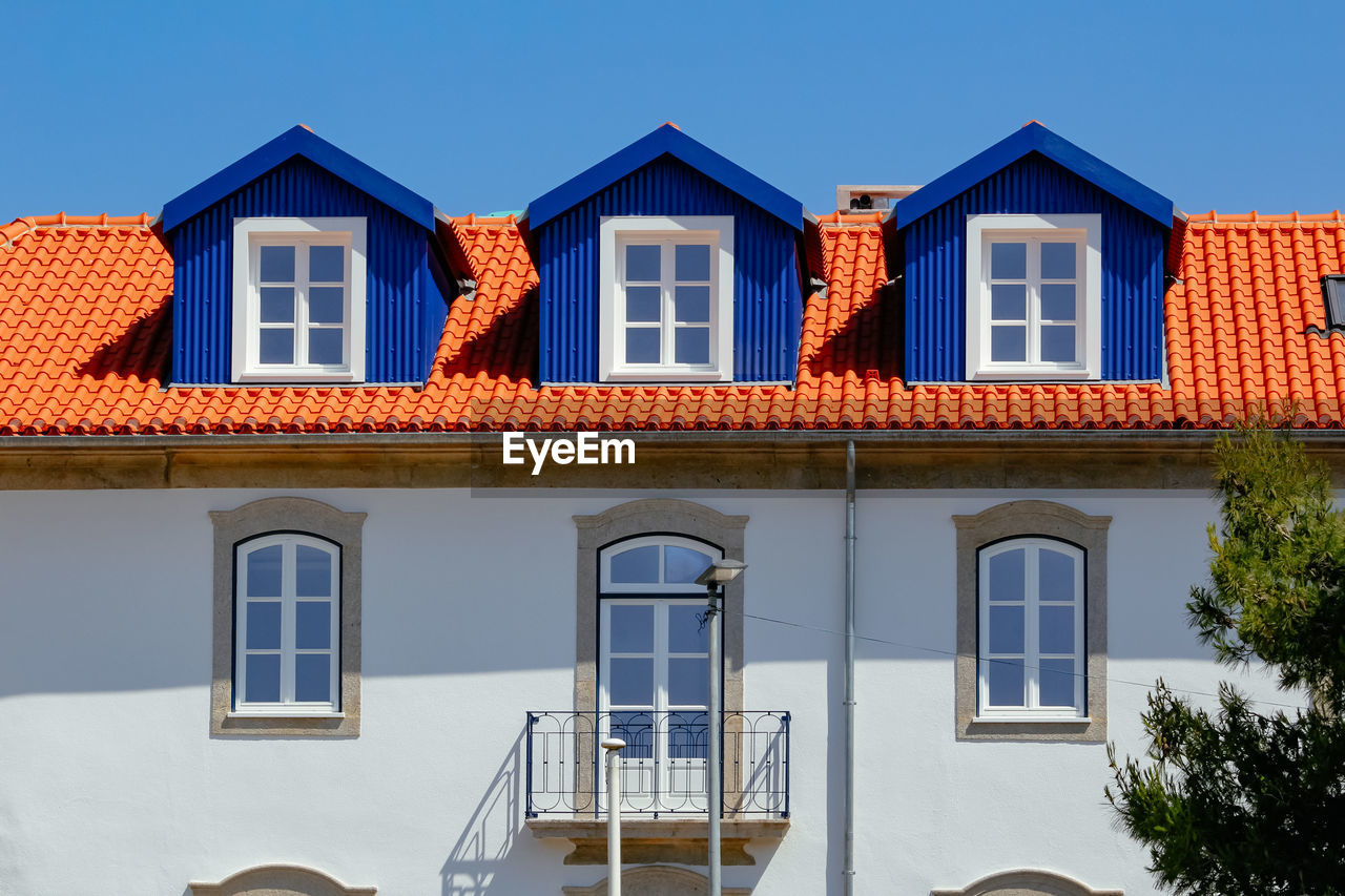 LOW ANGLE VIEW OF RESIDENTIAL BUILDING AGAINST CLEAR SKY