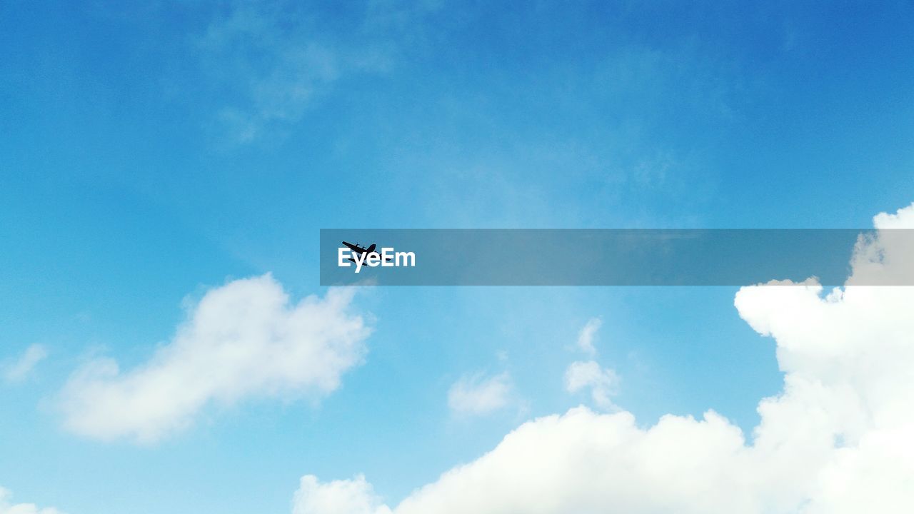 Low angle view of silhouette airplane against sky