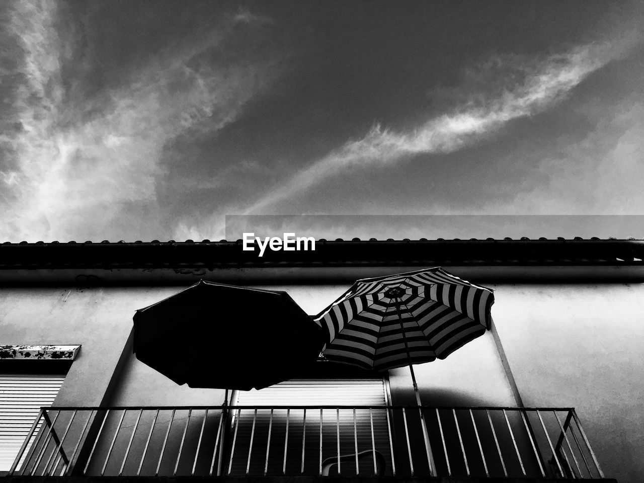 Low angle view of open umbrellas in balcony against sky