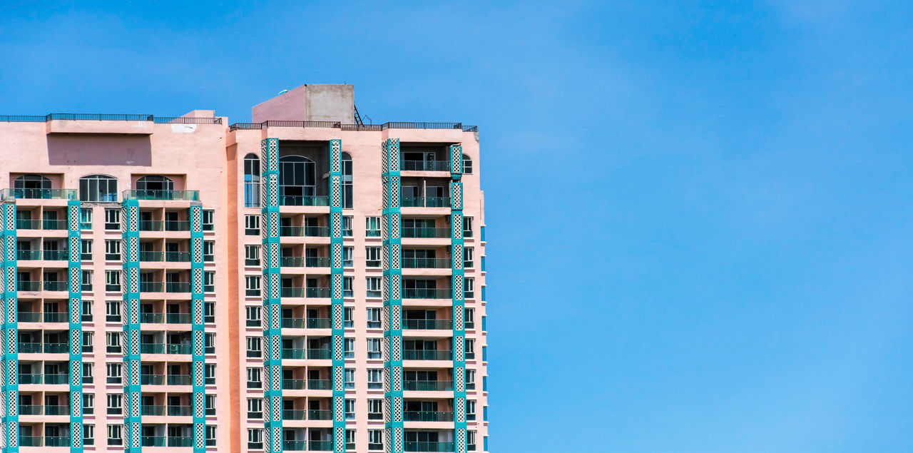 LOW ANGLE VIEW OF BUILDINGS AGAINST BLUE SKY