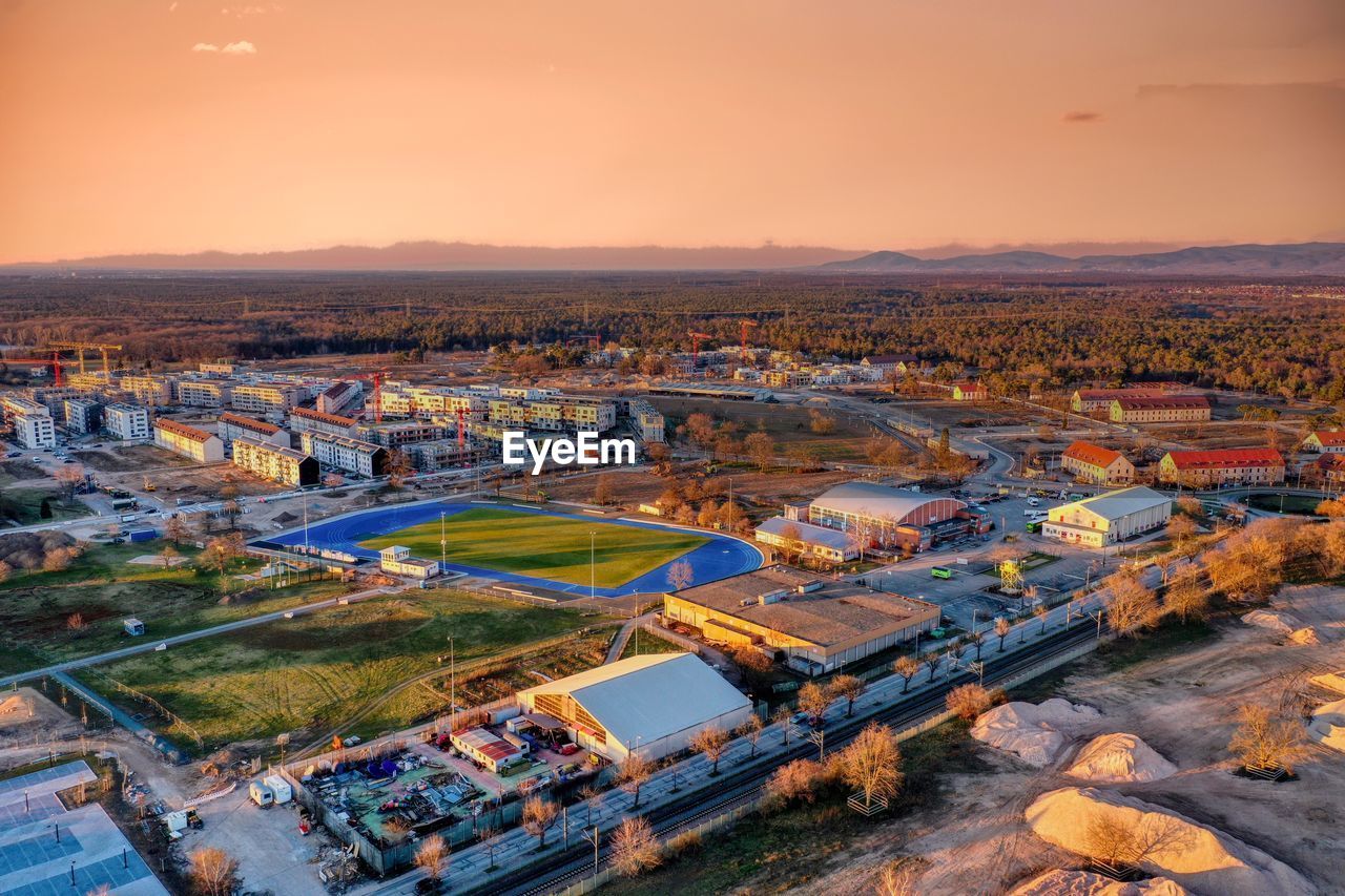 High angle view of city buildings against sky during sunset