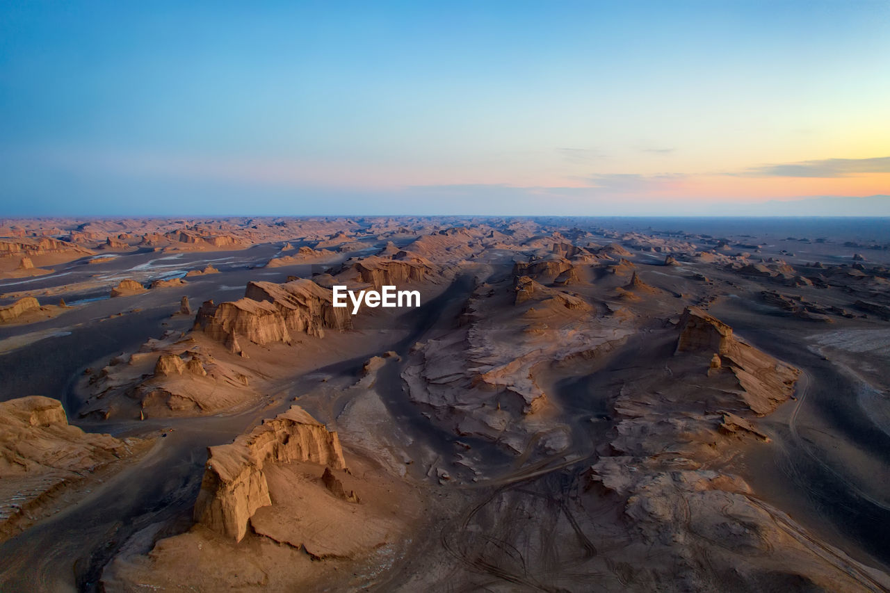 Scenic view of desert against sky during sunset