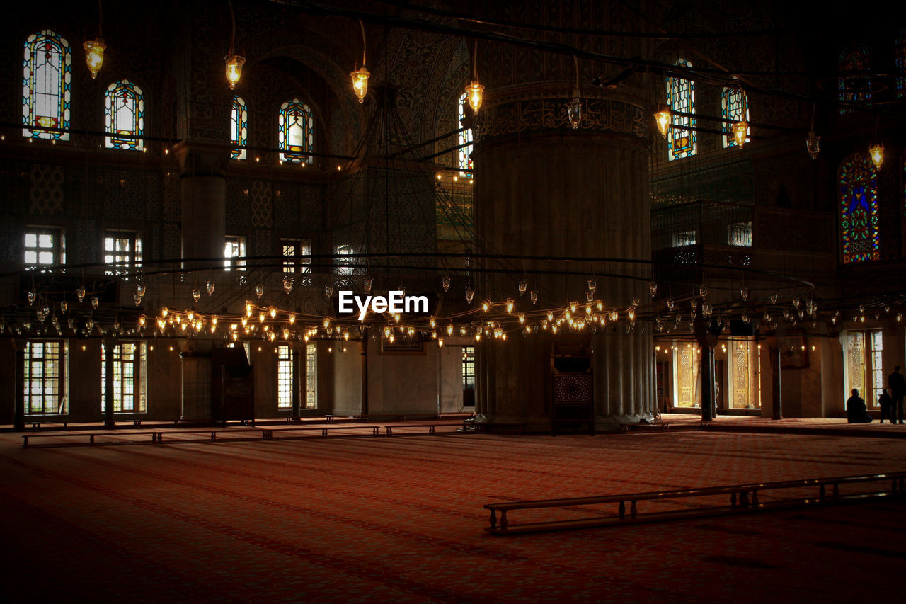Illuminated chandelier hanging in historic building
