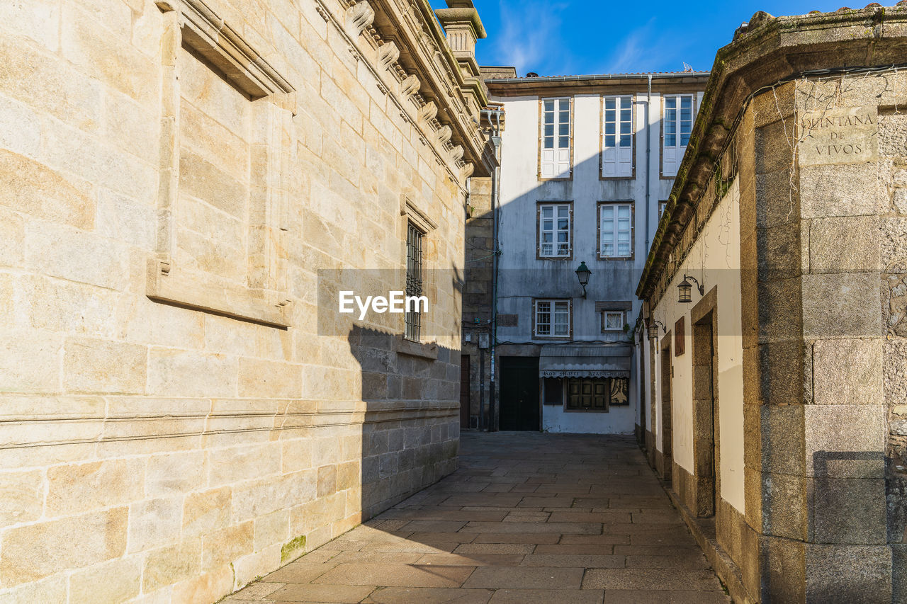 architecture, built structure, building exterior, wall, alley, street, road, ancient history, town, building, city, history, wall - building feature, the past, travel destinations, urban area, no people, infrastructure, sky, nature, facade, tourism, travel, outdoors, day, old, sunlight, neighbourhood, residential district, footpath