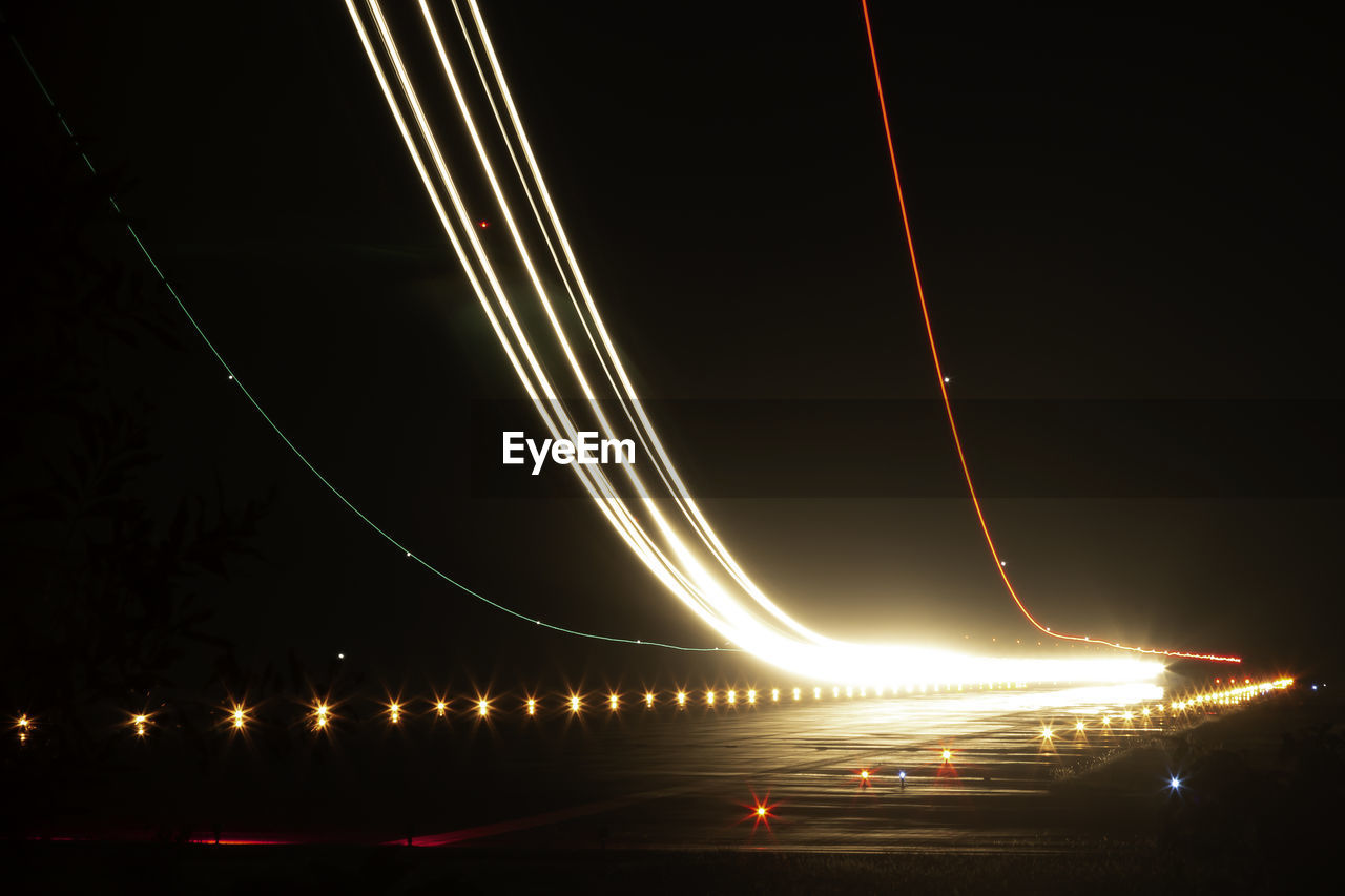 Illuminated light trails on runway at night