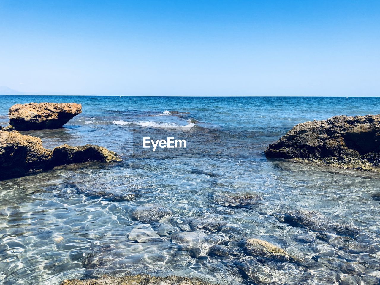 Scenic view of sea against clear blue sky