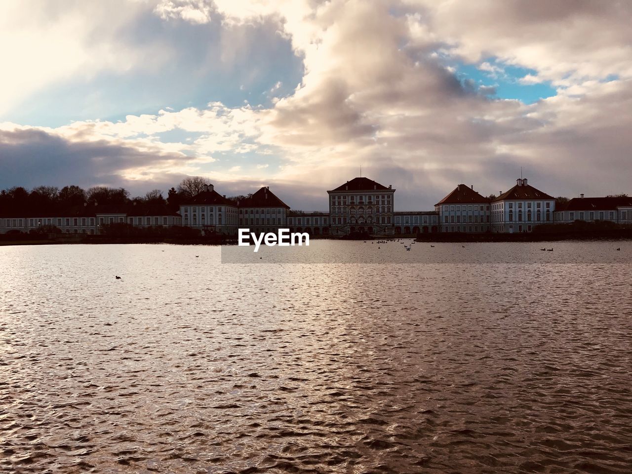 VIEW OF HOUSES BY LAKE AGAINST SKY