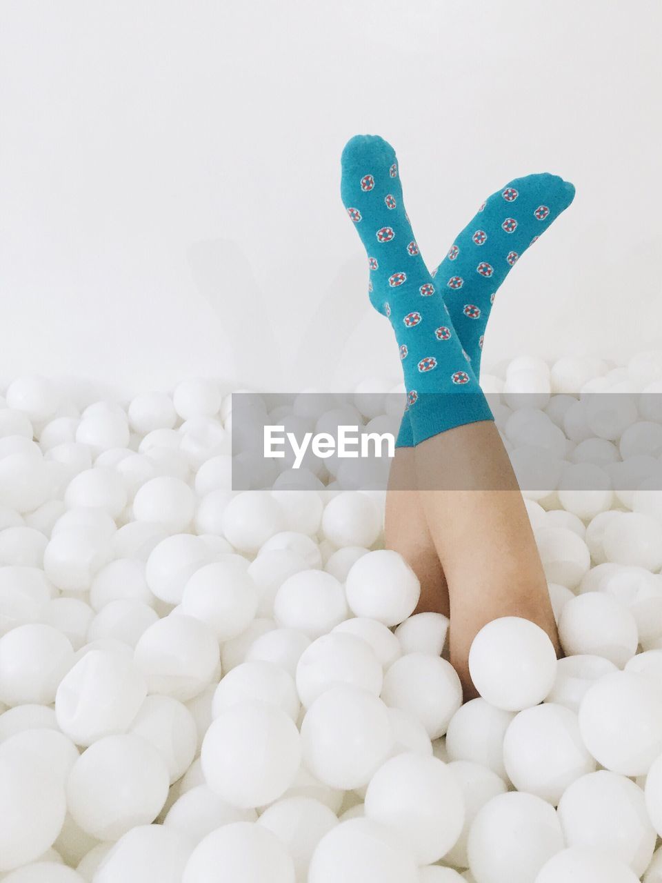 Woman amidst balls against white background