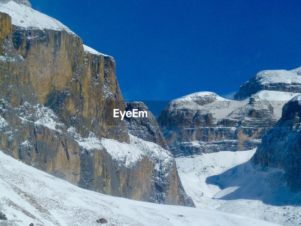 LOW ANGLE VIEW OF SNOWCAPPED MOUNTAINS AGAINST BLUE SKY