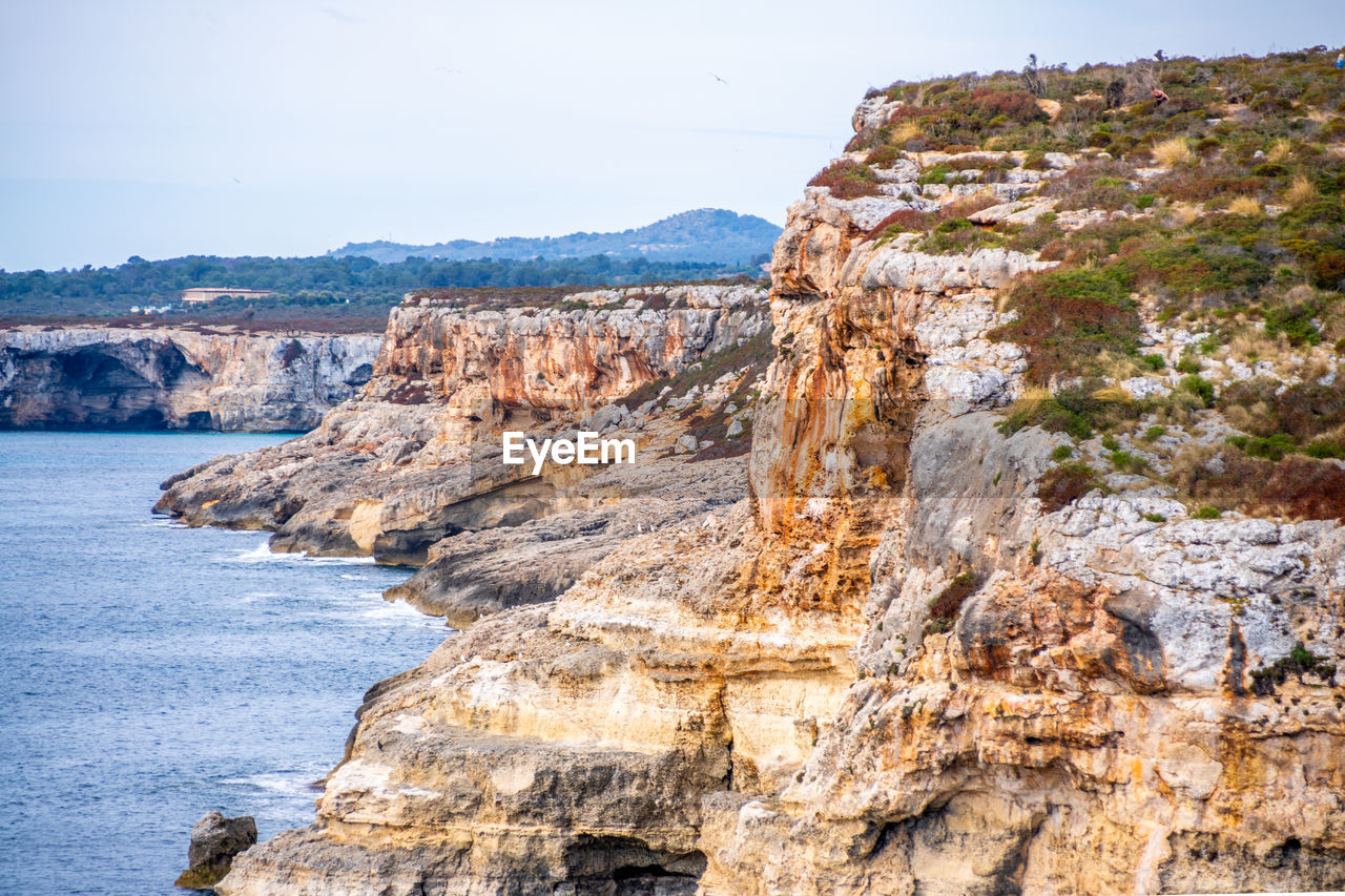 Rock formation on beach against sky