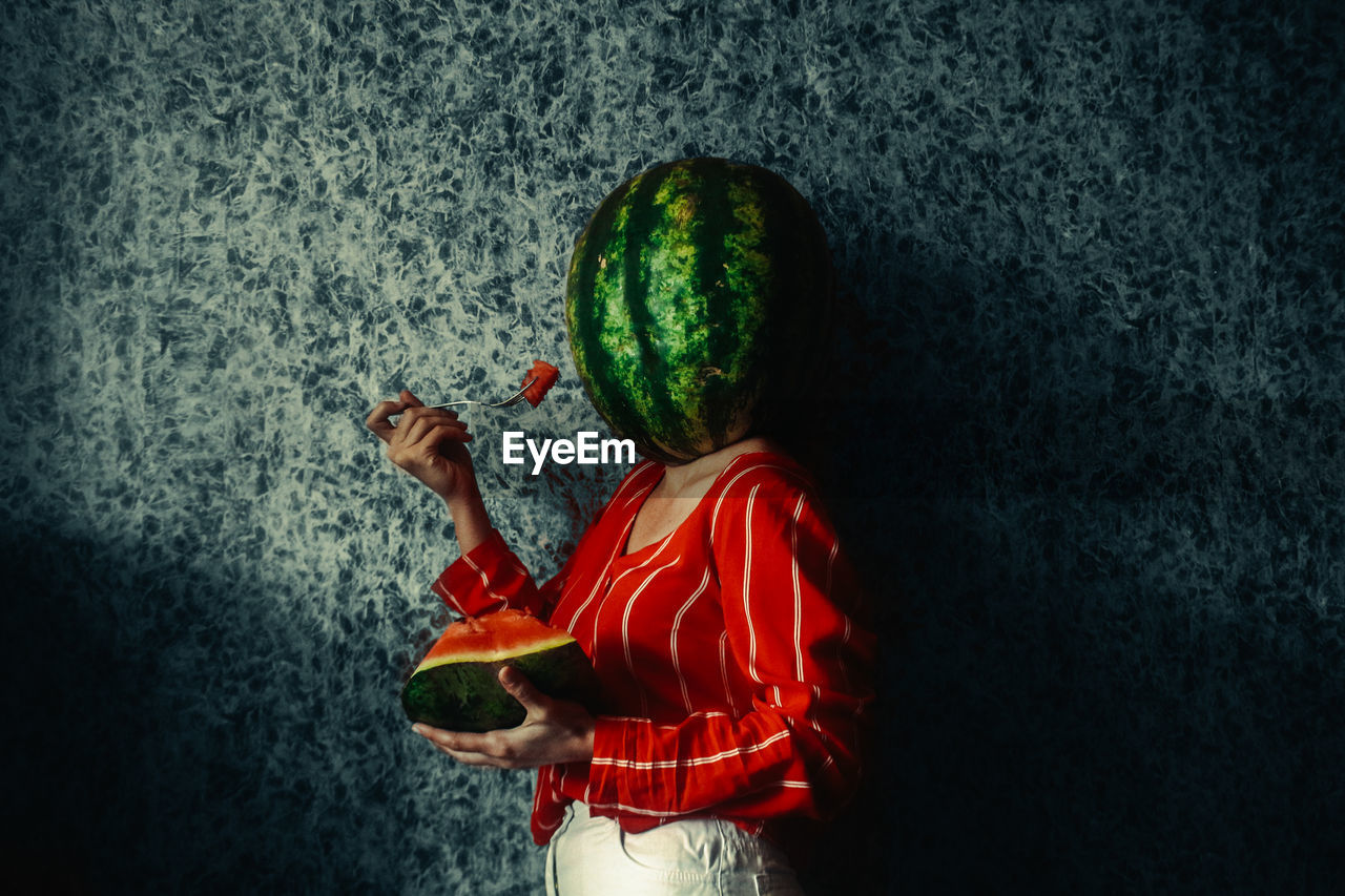 Rear view of girl holding fruit