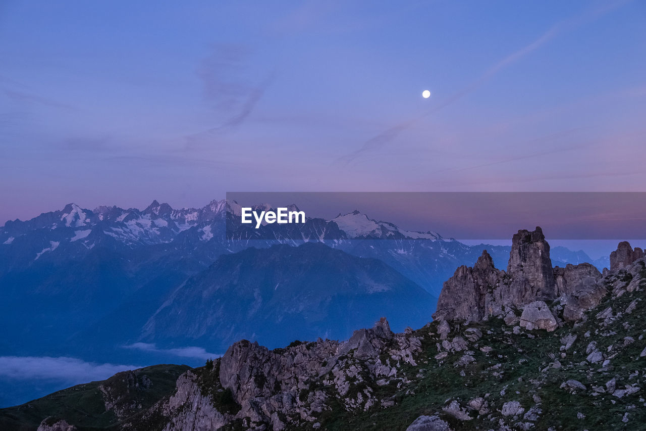 Scenic view of mountains against sky at night