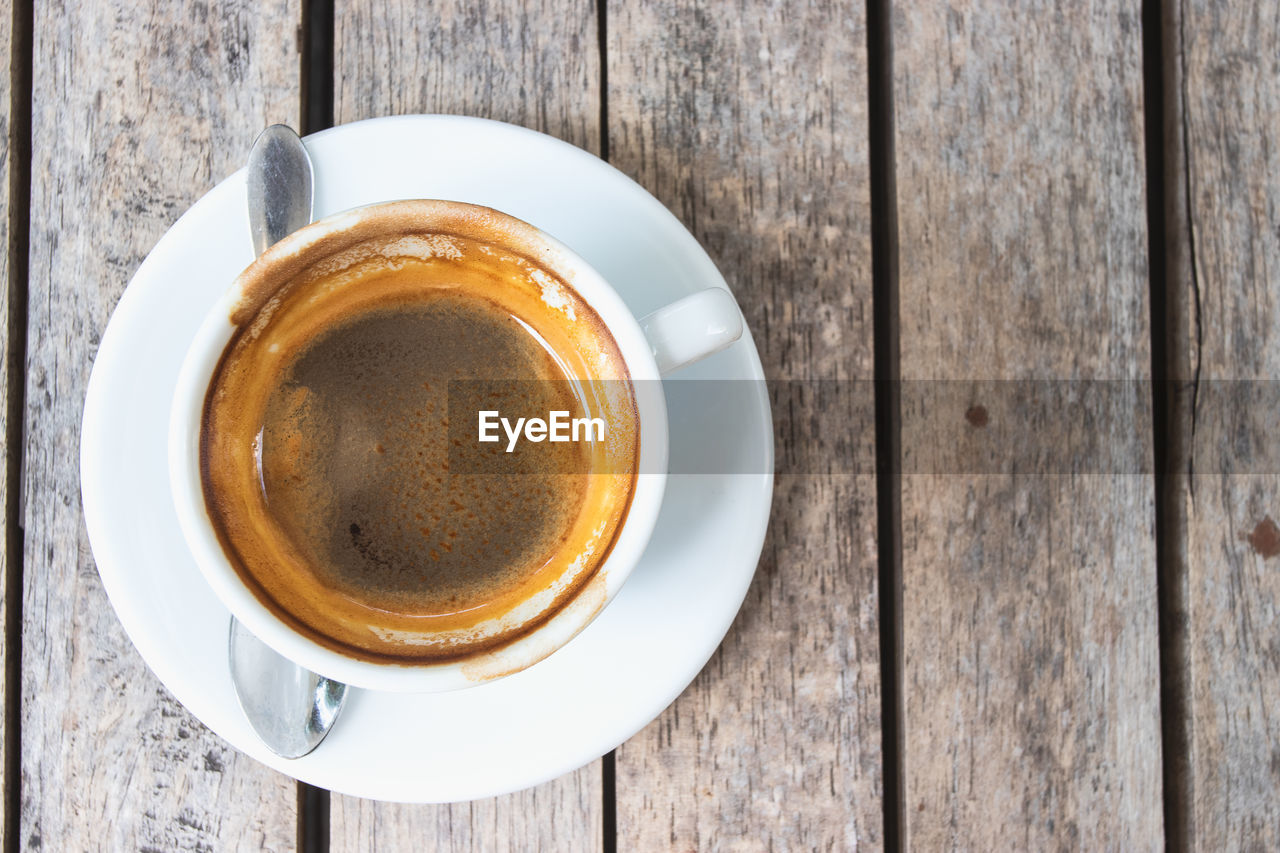 DIRECTLY ABOVE SHOT OF COFFEE CUP ON WOODEN TABLE