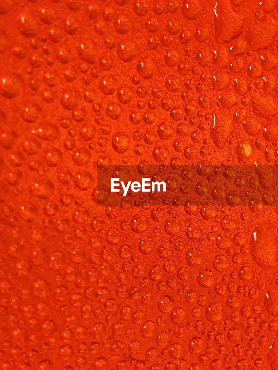 Full frame shot of water drops on orange surface