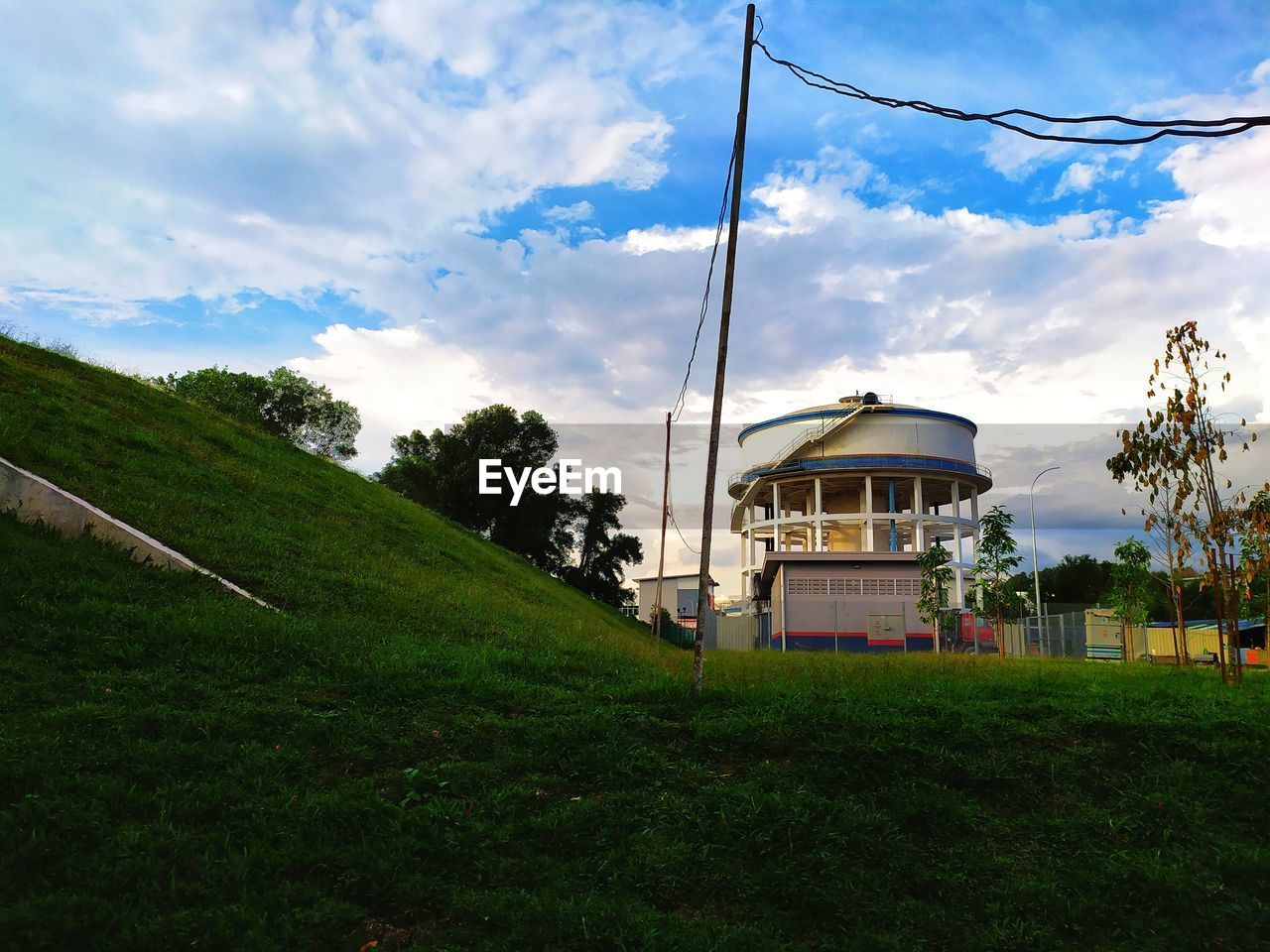 HOUSES ON FIELD AGAINST SKY