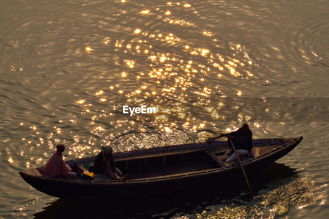 High angle view of people on fishing boat during sunset