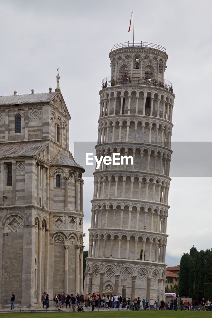 People in front of leaning tower of pisa against sky
