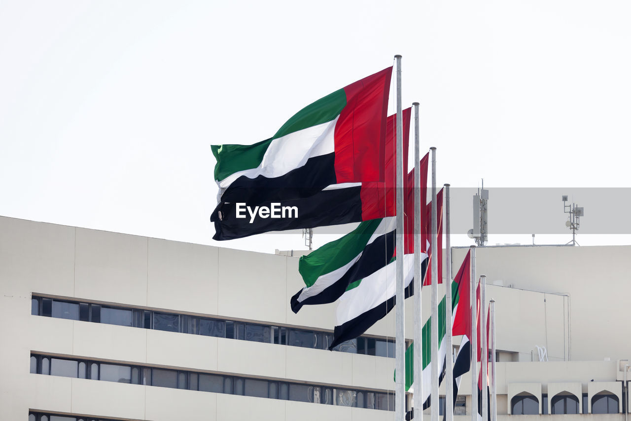 LOW ANGLE VIEW OF FLAG AGAINST BUILDINGS