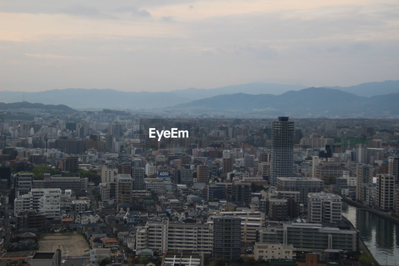 Aerial view of buildings in city against sky