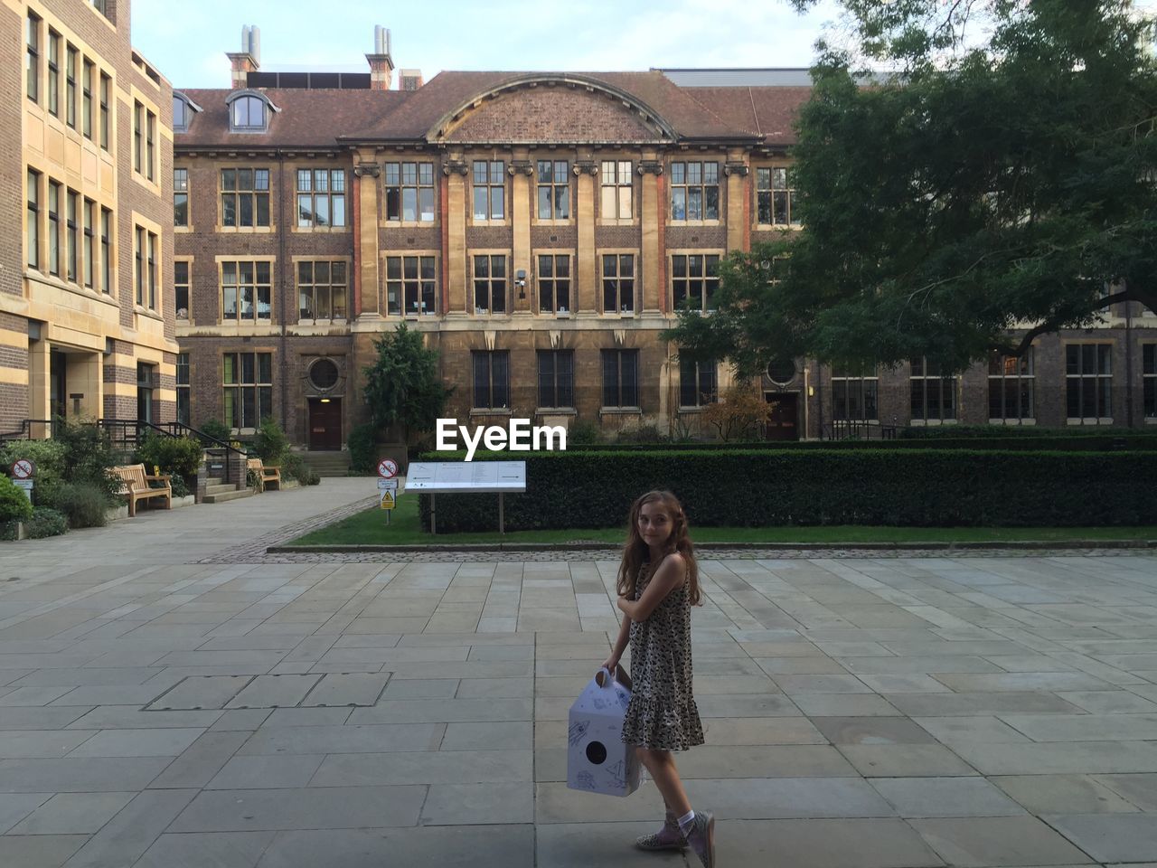 Teenage girl holding bag while standing at university of cambridge