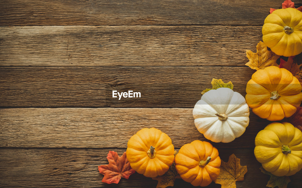 High angle view of pumpkins and leaves on table during autumn