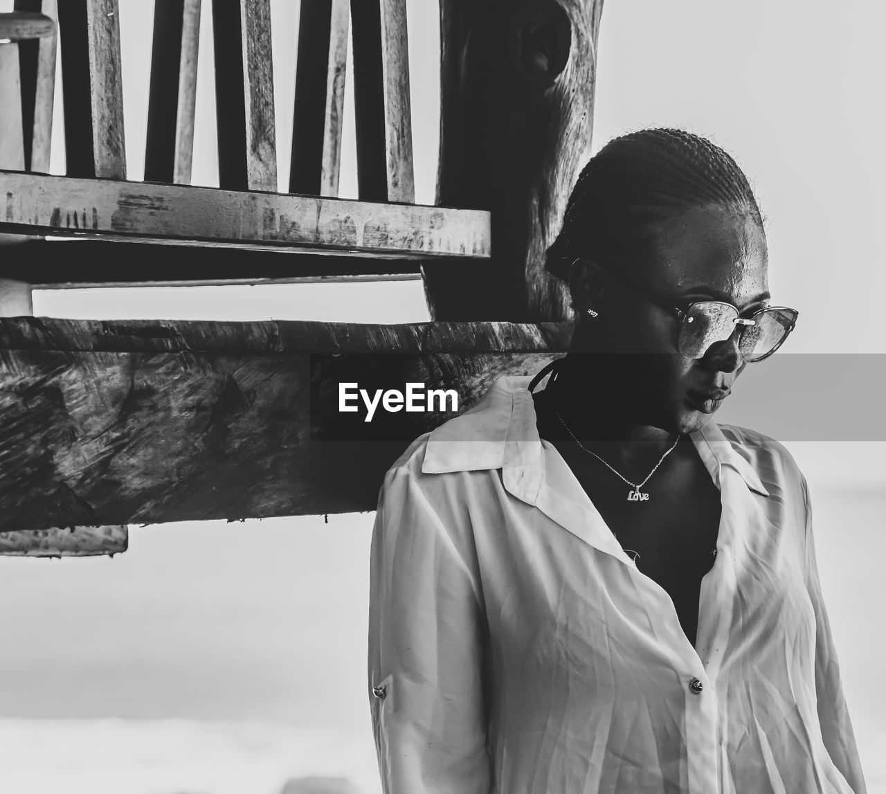 Woman wearing sunglasses while standing by balcony