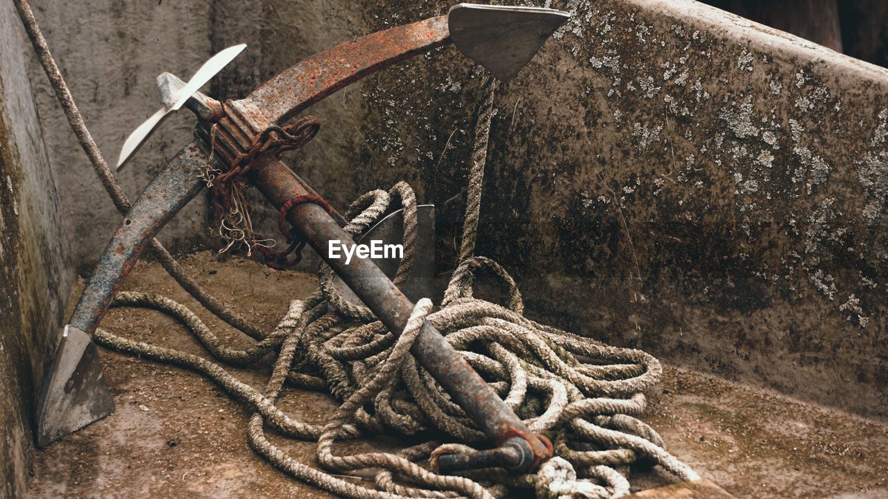 Close-up of rope tied on rusty metal chain