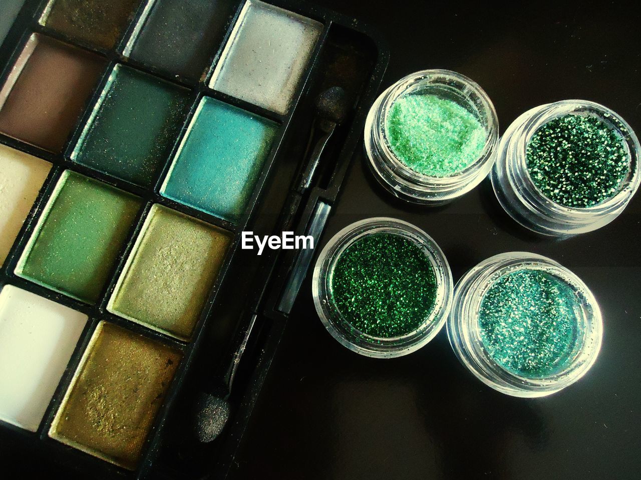 High angle view of eyeshadow next to glitters