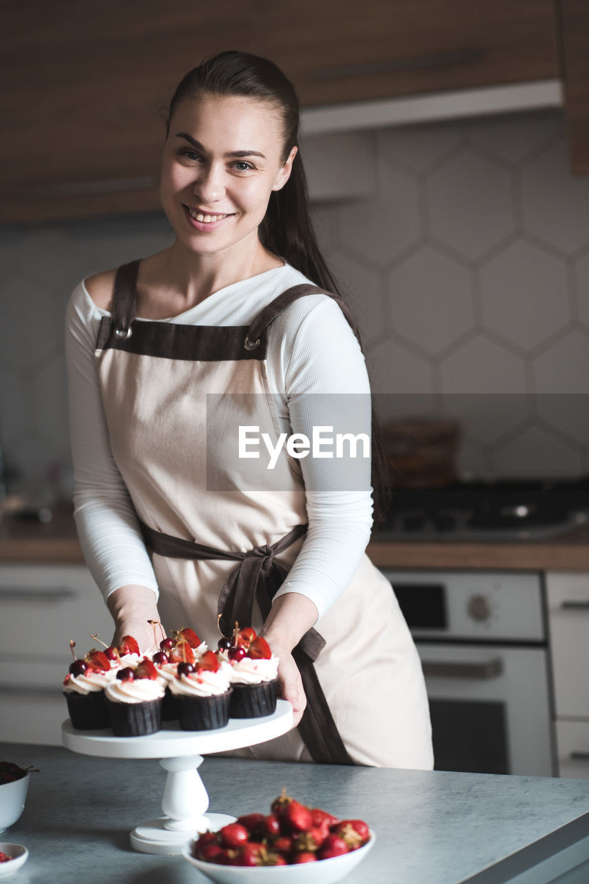 Portrait of smiling chef with cupcake kitchen