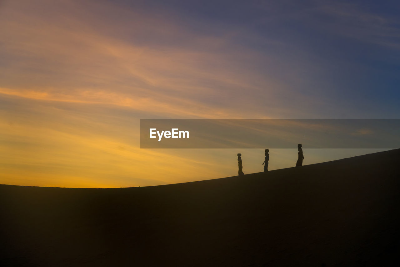 SILHOUETTE PEOPLE STANDING ON LAND AGAINST SKY AT SUNSET