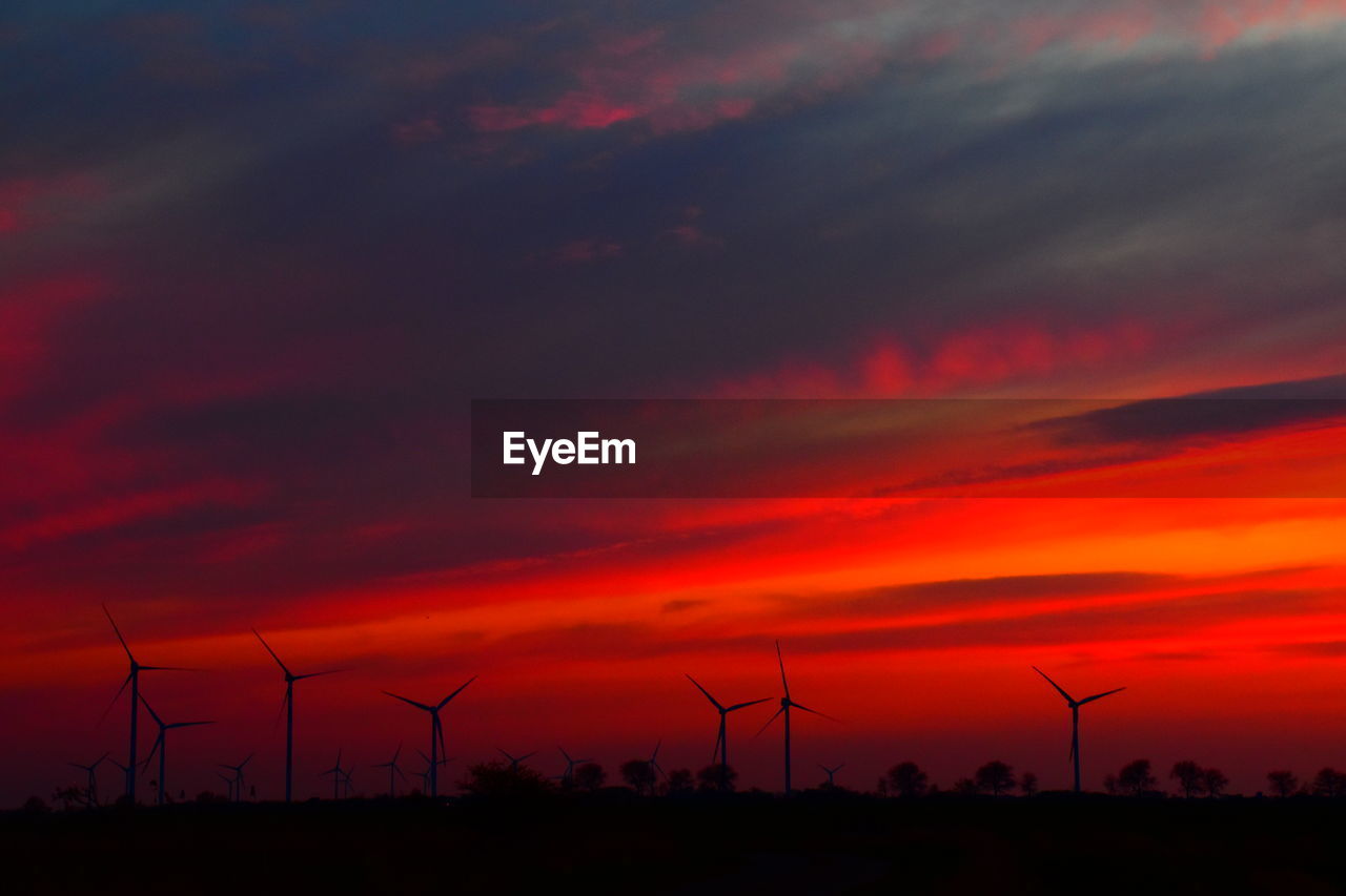 SILHOUETTE OF WIND TURBINES AT SUNSET