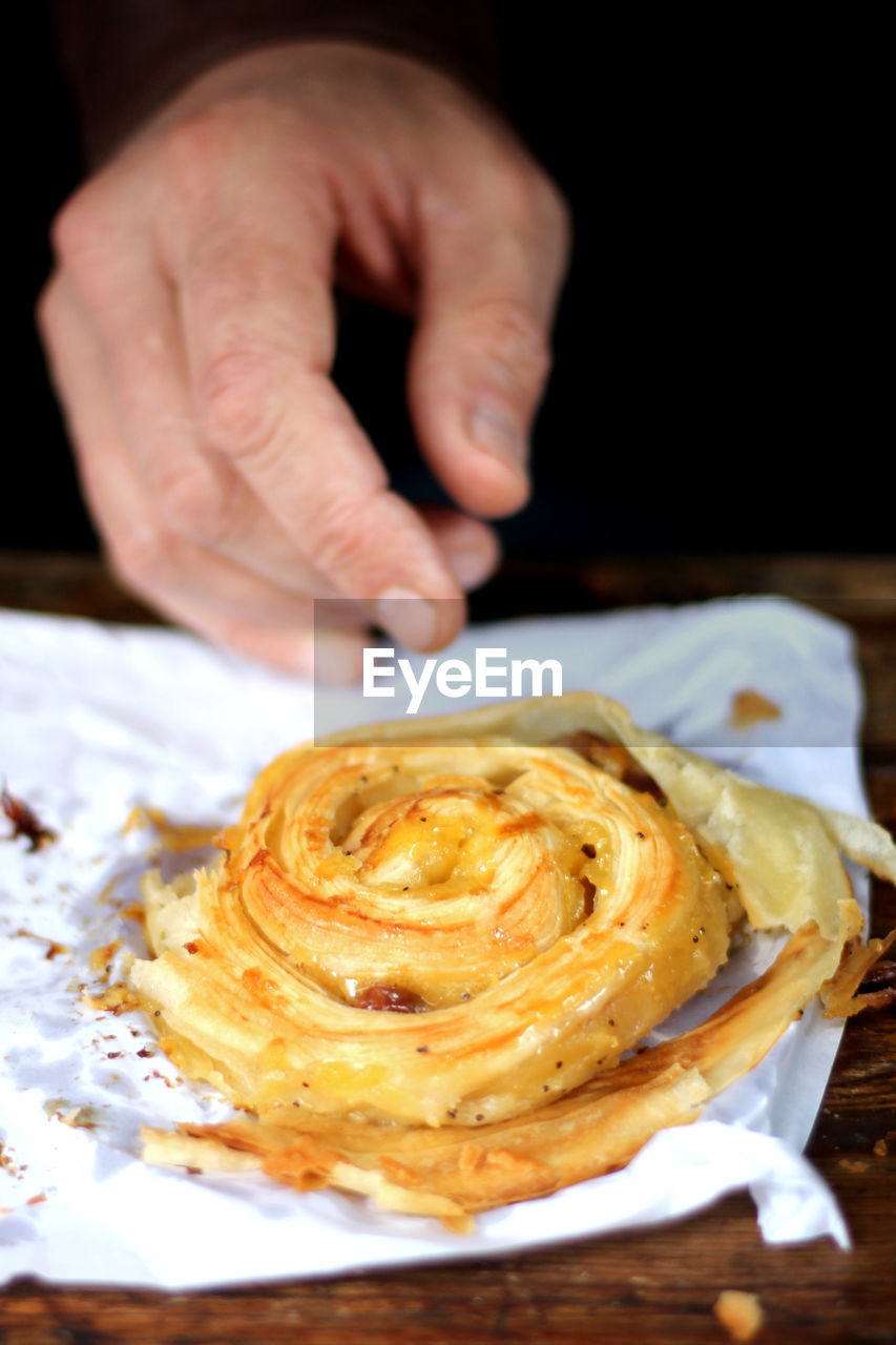 Close-up of hand reaching for pastry