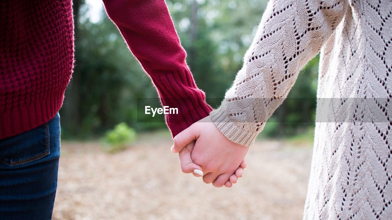 Cropped image of friends holding hands