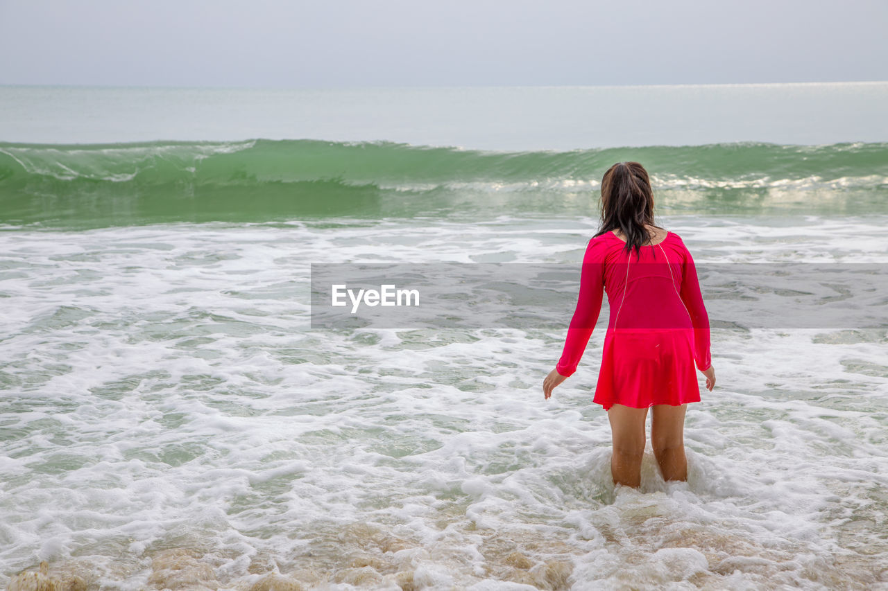 Rear view of girl standing on beach