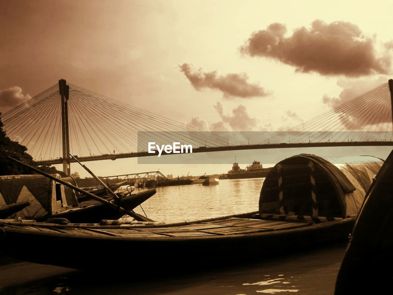 Boats moored on river against bridge