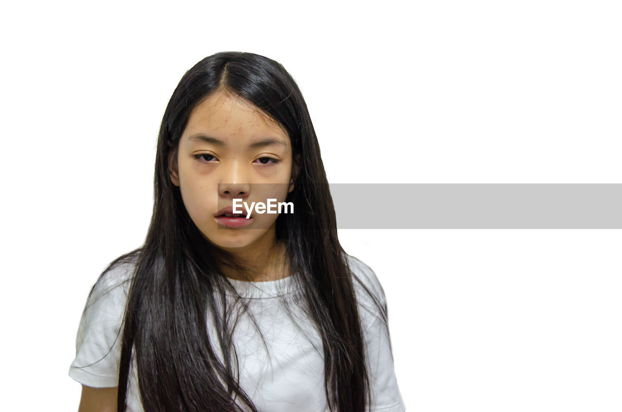 PORTRAIT OF TEENAGE GIRL AGAINST WHITE BACKGROUND