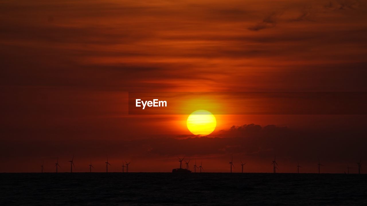 SCENIC VIEW OF SEA AGAINST DRAMATIC SKY DURING SUNSET