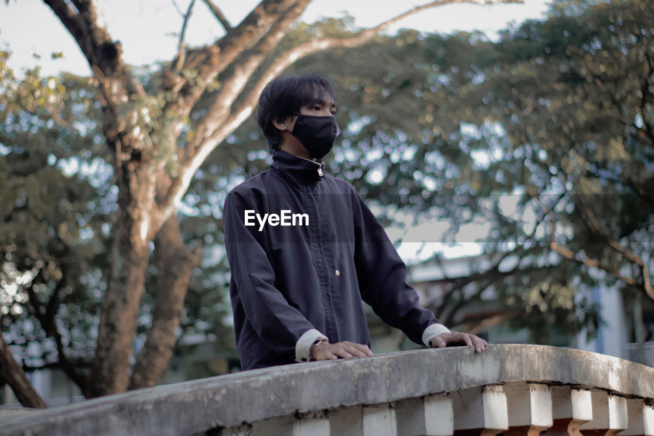 Low angle view of man standing against trees