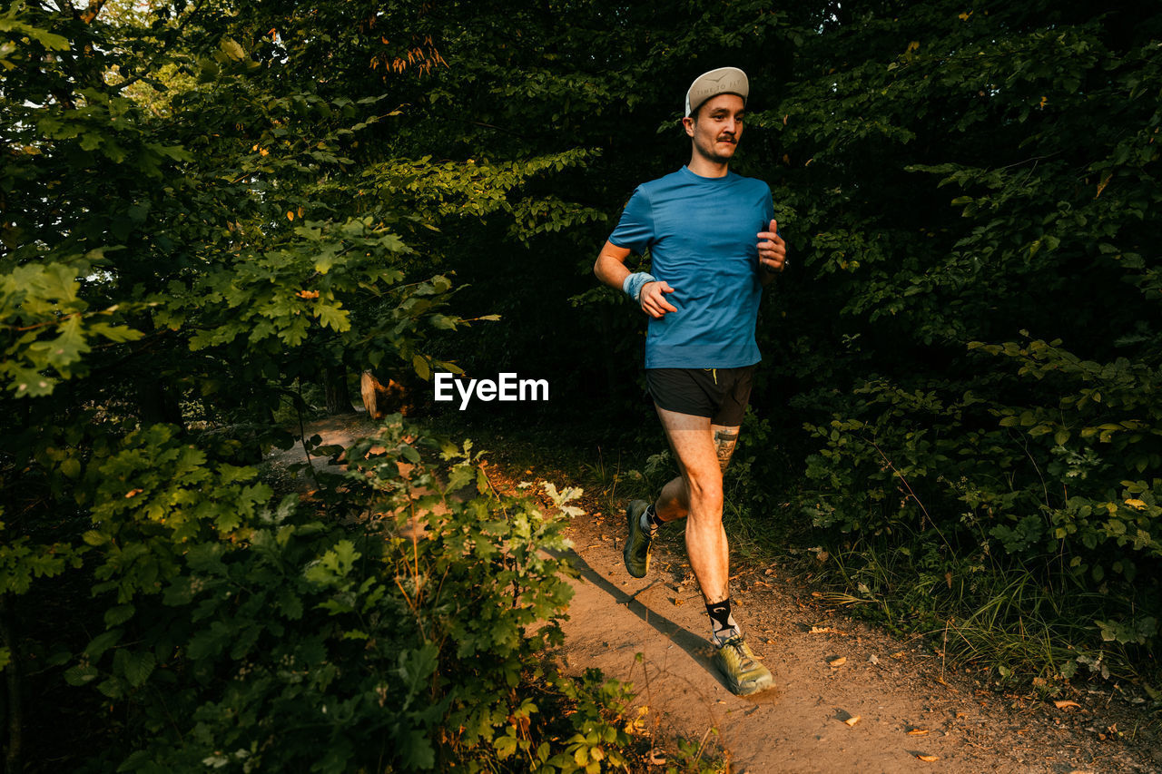 Full length of man running amidst plants