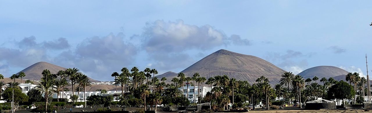 architecture, sky, tree, landmark, panoramic, built structure, tropical climate, travel destinations, nature, cloud, plant, palm tree, travel, building exterior, environment, monument, no people, tourism, building, outdoors, religion, landscape, city, land, mountain, beauty in nature, scenics - nature