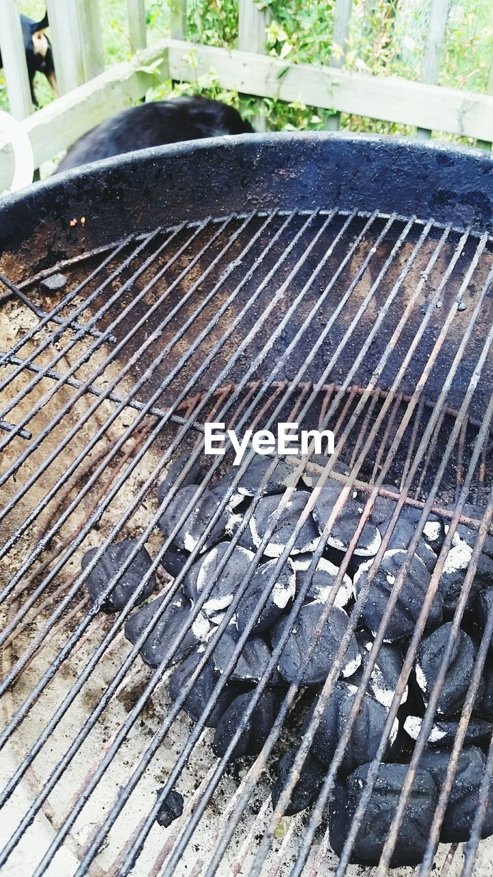 CLOSE-UP OF METAL GRATE AGAINST BLURRED BACKGROUND