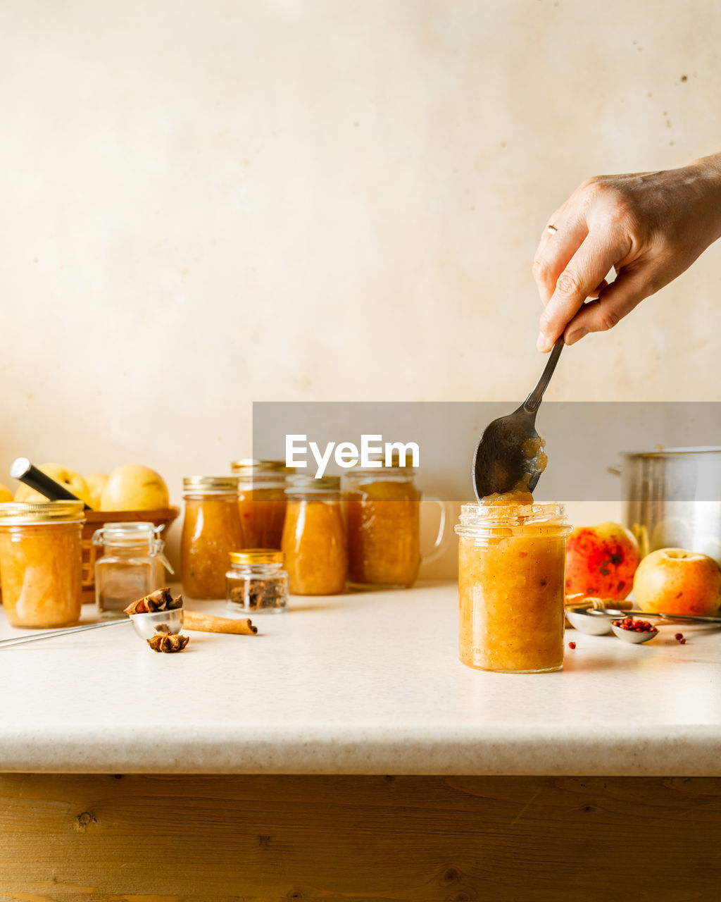 Woman filling glass jars with homemade apple sauce