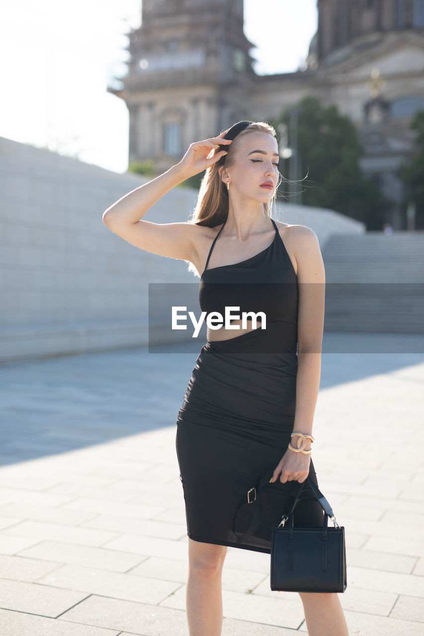 Portrait of young woman standing in city