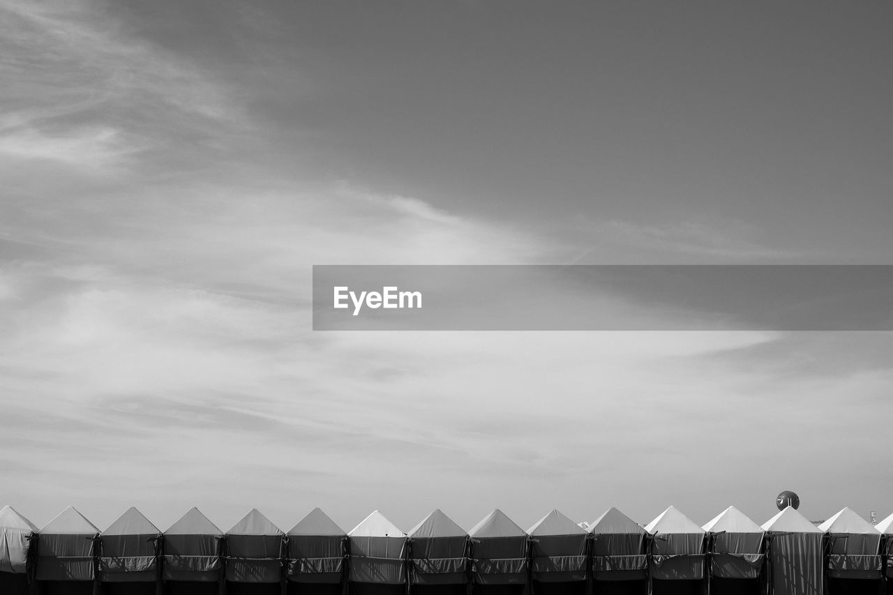 Beach huts in row against sky