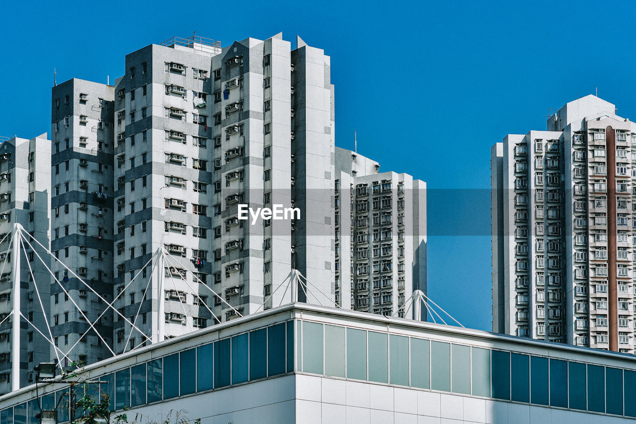 LOW ANGLE VIEW OF BUILDINGS AGAINST BLUE SKY