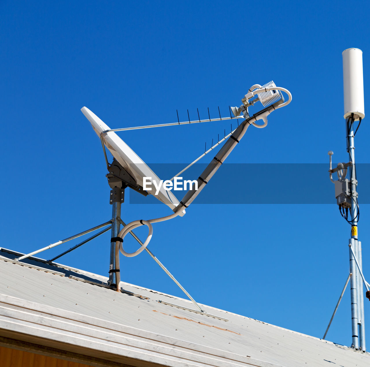 LOW ANGLE VIEW OF COMMUNICATIONS TOWER AGAINST BLUE SKY