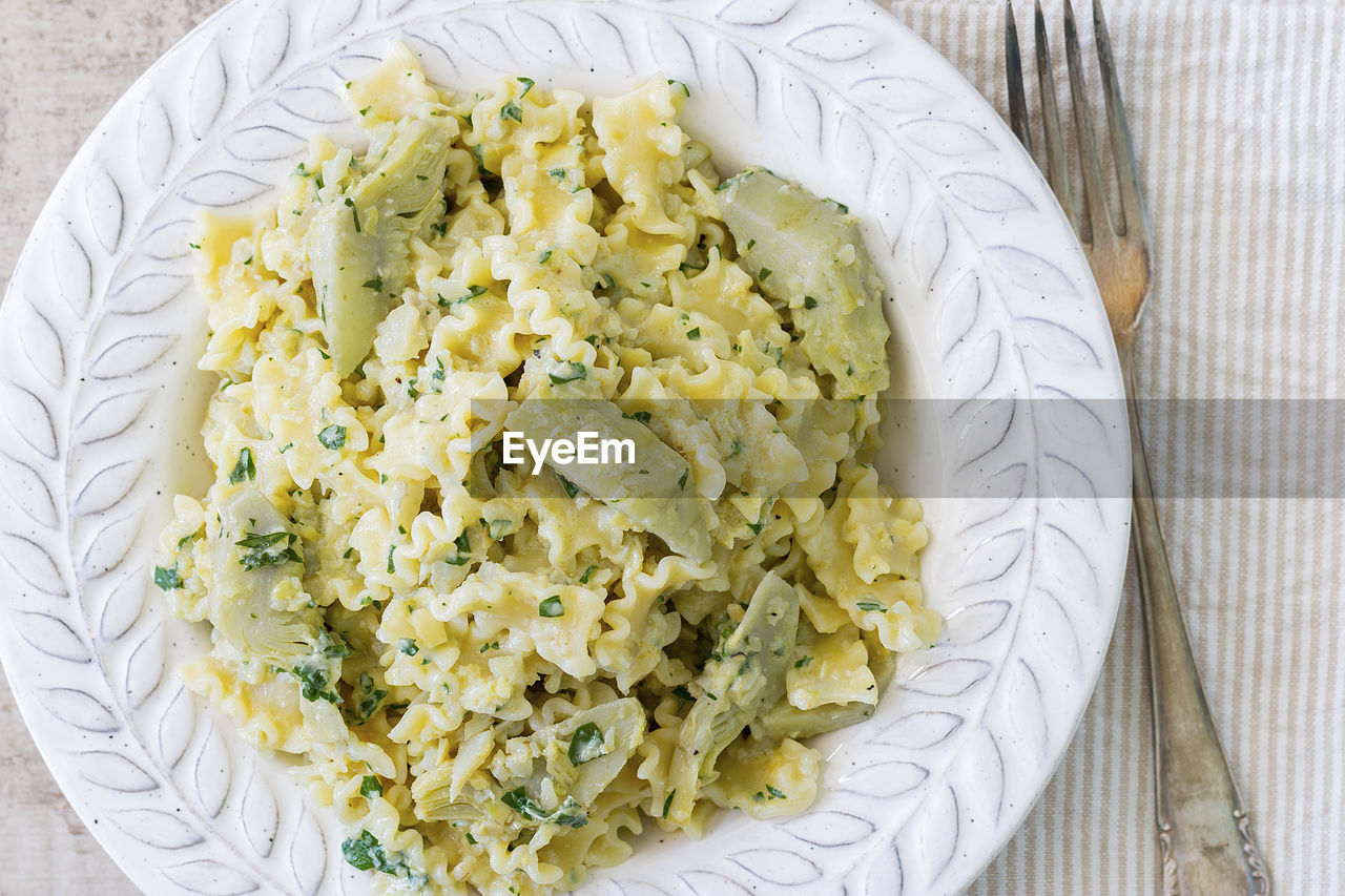 A plate with pasta and artichokes from above.